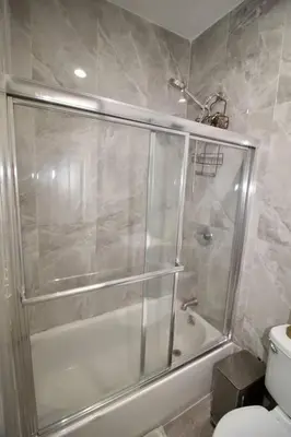 a bathroom with a shower and a toilet at Tuk Ahoy - Emerald Suite 2C with Shared Spaces in Brooklyn