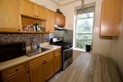 a kitchen with a sink and a stove and a window at Tuk Ahoy - Emerald Suite 2C with Shared Spaces in Brooklyn