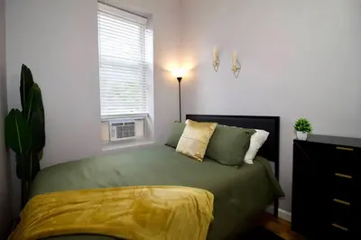 a bedroom with a green bed and a window at Tuk Ahoy - Emerald Suite 2C with Shared Spaces in Brooklyn