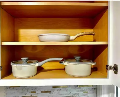 two pots and pans sitting inside of a cabinet at 0-A Diamond in Yonkers, NY in Yonkers