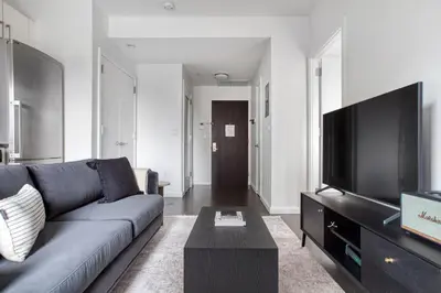 a living room with a couch and a flat screen tv at Gorgeous Midtown W 1BR w Gym nr Times Sq NYC-651 in New York