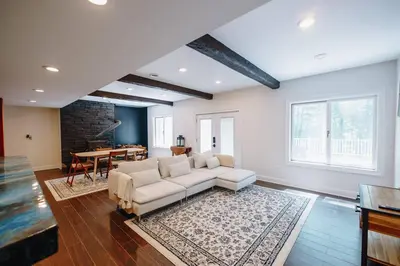 a living room with a white couch and a table at The Athena Hideaway - hottub, firepit, lake & racetrack in Saratoga Springs