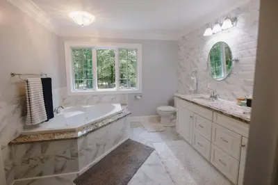 a white bathroom with a tub and a sink at The Athena Hideaway - hottub, firepit, lake & racetrack in Saratoga Springs