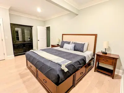 a bedroom with a large bed and a night stand at The Athena Hideaway - hottub, firepit, lake & racetrack in Saratoga Springs
