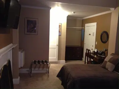 a bedroom with a bed and a desk and a table at The Tunnicliff Inn in Cooperstown