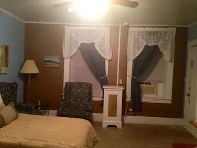 a bedroom with a bed and a window with curtains at The Tunnicliff Inn in Cooperstown
