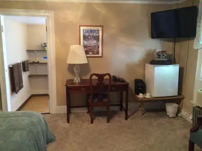 a bedroom with a desk and a chair and a television at The Tunnicliff Inn in Cooperstown