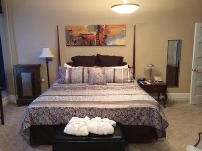 a bedroom with a large bed with two pairs of shoes at The Tunnicliff Inn in Cooperstown