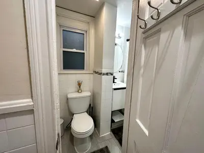 a small bathroom with a toilet and a window at 1-A Diamond in Yonkers, NY in Yonkers
