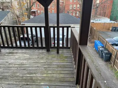 a porch with a wooden deck with a fence at Frog Hollow Red Door Haven in Hartford