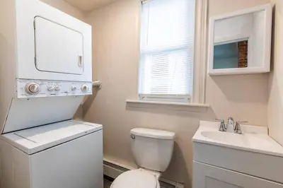 a white bathroom with a toilet and a sink at Frog Hollow Red Door Haven in Hartford