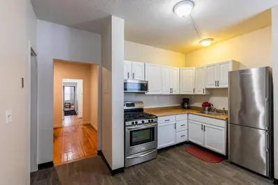 a kitchen with white cabinets and a stainless steel refrigerator at Frog Hollow Red Door Haven in Hartford