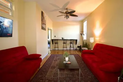 a living room with two red couches and a table at Tuk Ahoy - Emerald Suite 3C with Shared Spaces in Brooklyn