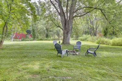 three chairs sitting in the grass in a field at Peaceful Upstate New York Home with Yard and Fire Pit! in Walden