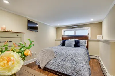 a bedroom with a bed with blue pillows and a window at New Fairfield Vacation Rental with Lake Views! in New Fairfield
