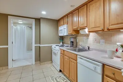 a kitchen with wooden cabinets and a sink at New Fairfield Vacation Rental with Lake Views! in New Fairfield