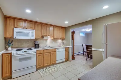 a kitchen with wooden cabinets and white appliances at New Fairfield Vacation Rental with Lake Views! in New Fairfield