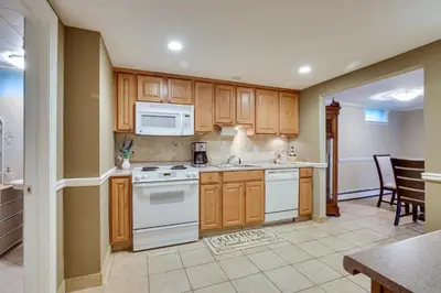 a kitchen with white appliances and wooden cabinets at New Fairfield Vacation Rental with Lake Views! in New Fairfield