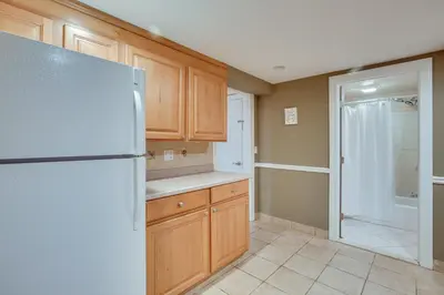 a kitchen with wooden cabinets and a refrigerator at New Fairfield Vacation Rental with Lake Views! in New Fairfield