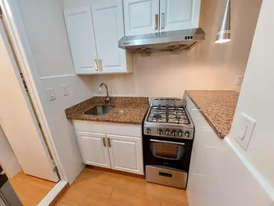 a small kitchen with a stove and a sink at Comfortable Apartment with Workstation in New York