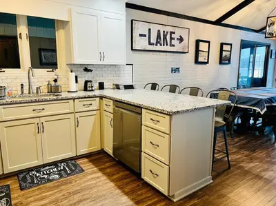 a kitchen with white cabinets and a counter top at Lakeside Oasis with Kayaks, Hot Tub, & Fire Pit in Clifton