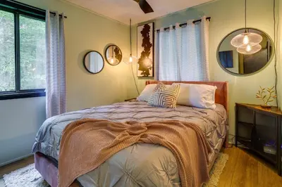 a bedroom with a bed and a mirror at Deck, Fire Pit and Sauna Big Bass Lake Getaway! in Clifton