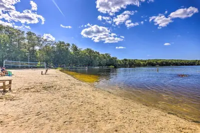 a sandy beach next to a body of water at Deck, Fire Pit and Sauna Big Bass Lake Getaway! in Clifton