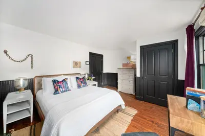 a bedroom with a white bed and a black door at Hotel Mountain Brook in Tannersville