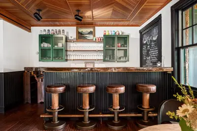 a bar with wooden ceilings and wooden stools at Hotel Mountain Brook in Tannersville
