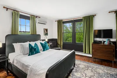 a bedroom with a large bed and a television at Hotel Mountain Brook in Tannersville