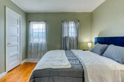 a bedroom with a large bed with a blue headboard at Humble home with free breakfast offered if requested! in Chicopee