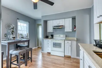 a kitchen with white cabinets and a stove top oven at Humble home with free breakfast offered if requested! in Chicopee