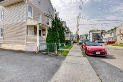 a red car parked on a street next to a house at Humble home with free breakfast offered if requested! in Chicopee
