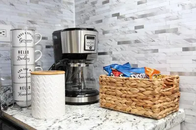 a counter with a coffee maker and a basket of food at Elegant 3Br Apt Yankee stadium in Melrose