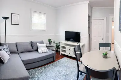a living room with a couch and a table at Historic peaceful apartment in New Haven