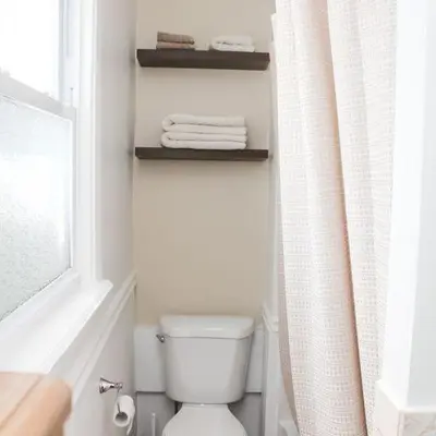 a bathroom with a toilet and a window and towels at Historic peaceful apartment in New Haven