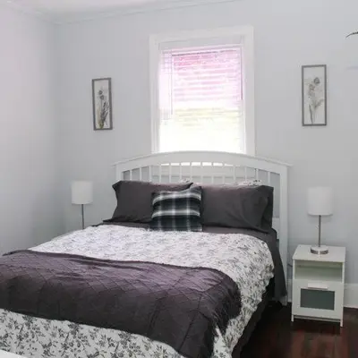 a bedroom with a bed and two lamps and a window at Historic peaceful apartment in New Haven