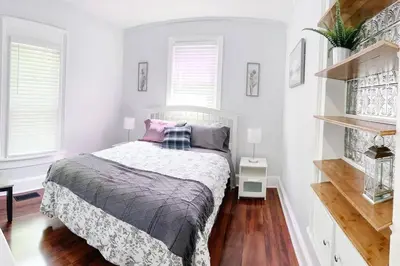 a bedroom with a bed in a white room at Historic peaceful apartment in New Haven