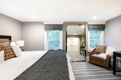 a bedroom with a large bed and a chair at Exquisite Bedford Lux Retreat. in Bedford