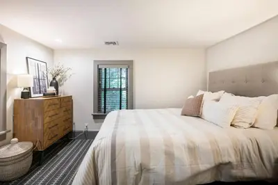 a white bedroom with a large bed and a dresser at Exquisite Bedford Lux Retreat. in Bedford
