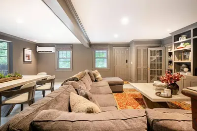 a living room with a large couch and a table at Exquisite Bedford Lux Retreat. in Bedford