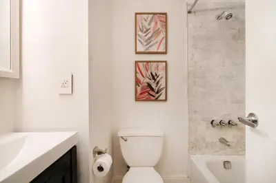 a white bathroom with a toilet and a shower at 1288-3RN New Renovated 1 Bedroom in UES in New York