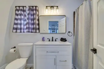 a bathroom with a toilet and a sink and a mirror at Community Perks Family Poconos Home with Deck! in Tobyhanna