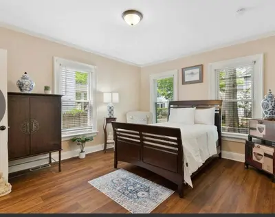 a bedroom with a bed and two windows at Beautiful Studio Apartment in Historic House in New Haven