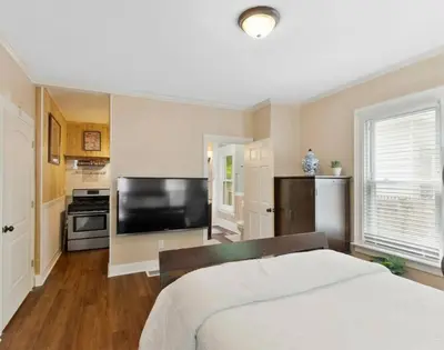 a bedroom with a bed and a flat screen tv at Beautiful Studio Apartment in Historic House in New Haven