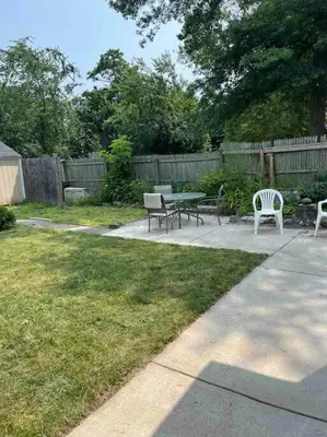 a picnic table and benches in a yard with a fence at Beautiful Studio Apartment in Historic House in New Haven