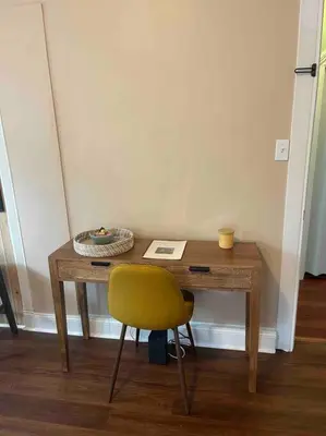 a wooden desk with a yellow chair and a book at Beautiful Studio Apartment in Historic House in New Haven