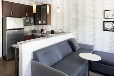 a living room with a couch and a kitchen at Residence Inn by Marriott Albany Clifton Park in Clifton Park