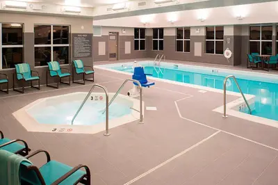 a swimming pool with a jacuzzi in a building at Residence Inn by Marriott Albany Clifton Park in Clifton Park
