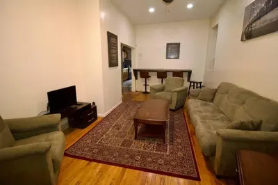 a living room with a couch and a table at Tuk Ahoy - Sunset Suite 2B with Shared Spaces in Brooklyn
